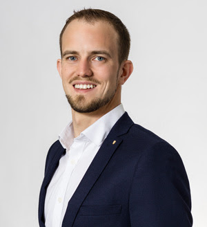 Portrait picture of Christoph Süess in a blue suit and white shirt.