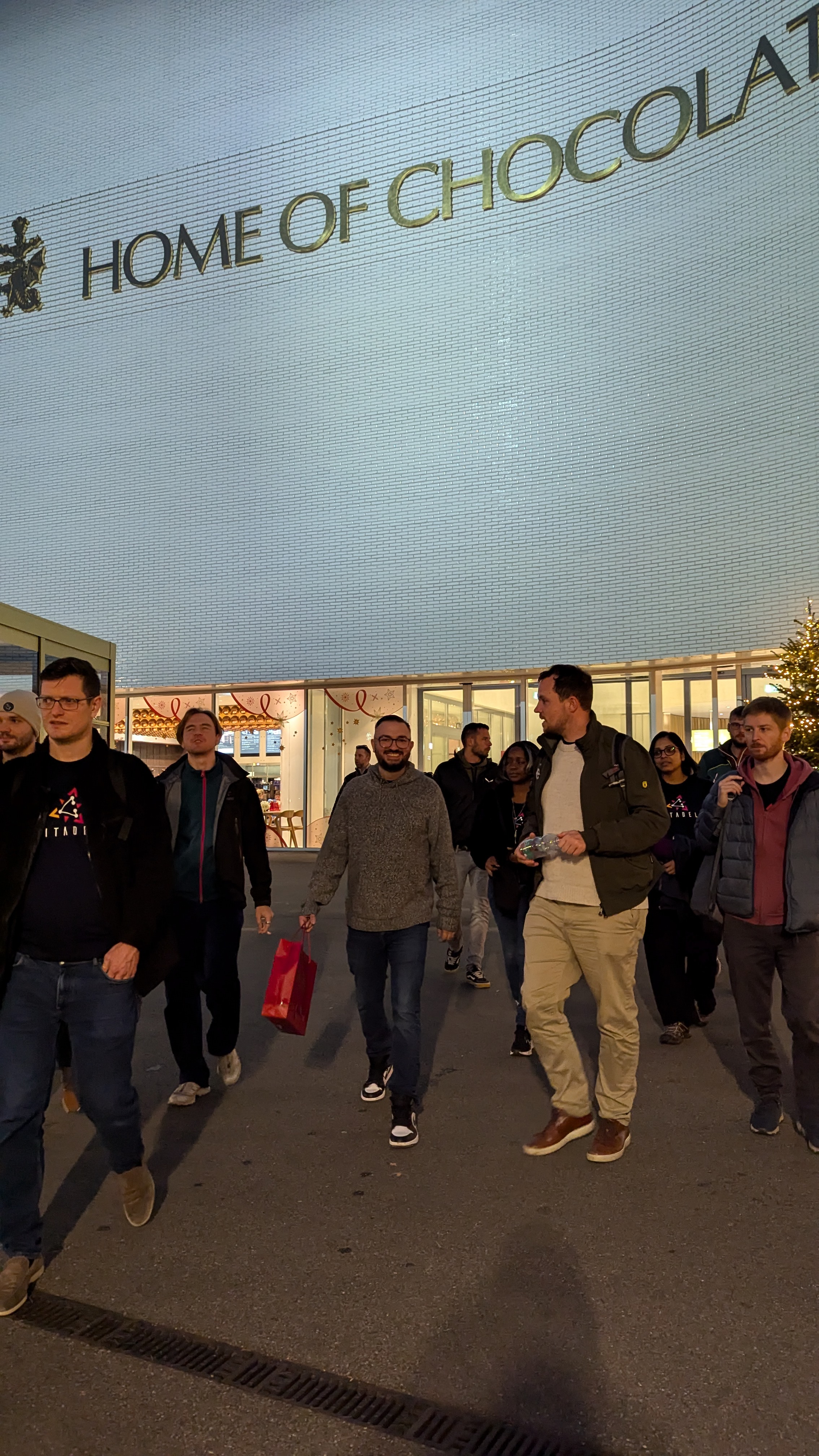 Group exiting the Lindt chocolate factory with the factory sign partially visible in the background.