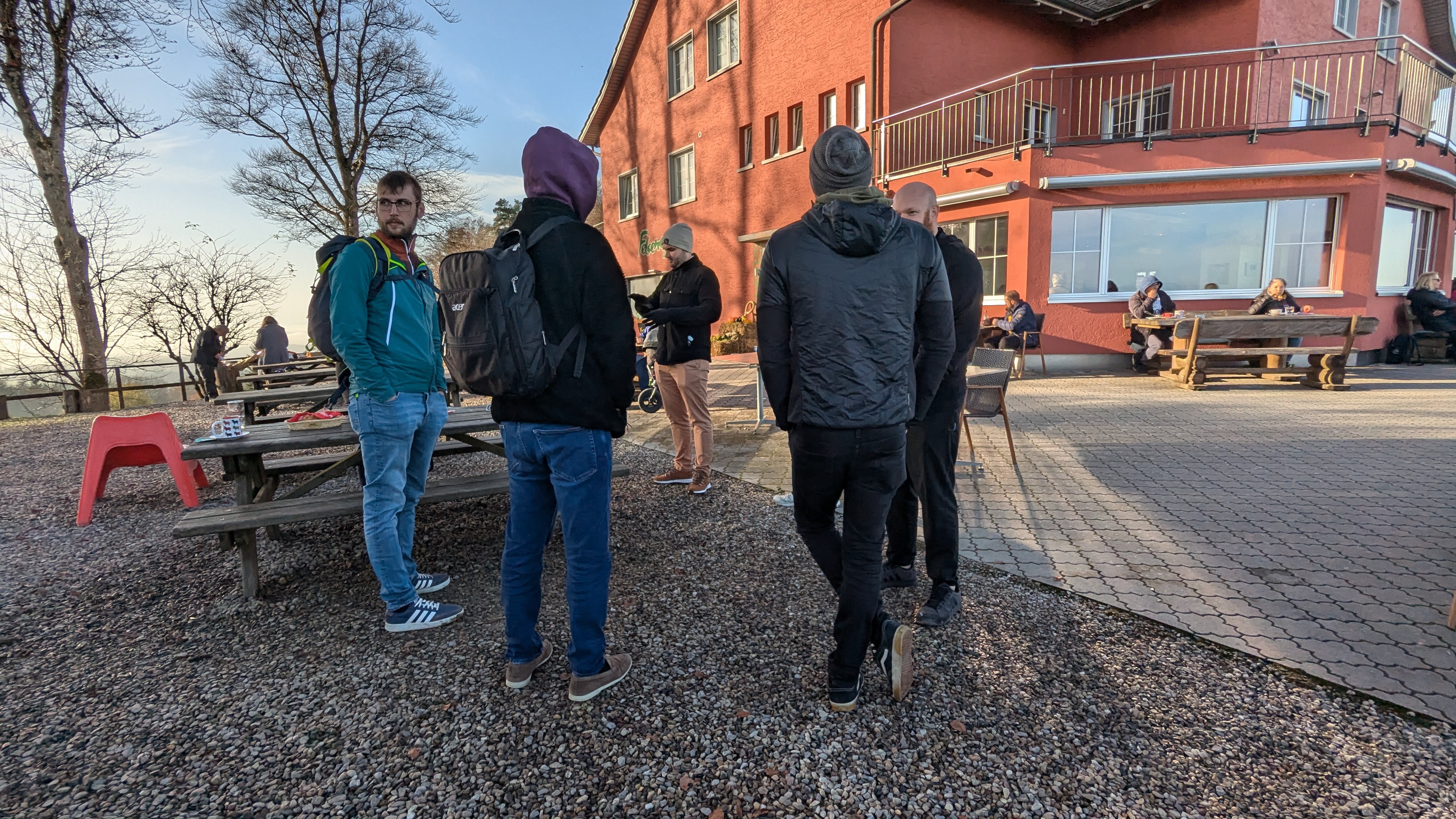 Small group of Zitadel engineers casually chatting near picnic-style seats at an outdoor restaurant.